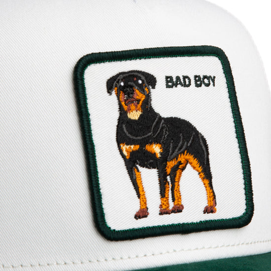 Weiße Trucker-Cap aus Mikrosuede mit grünem Goorin-Logo-Patch und schwarzem Hundemotiv, Aufschrift "Bad Boy".